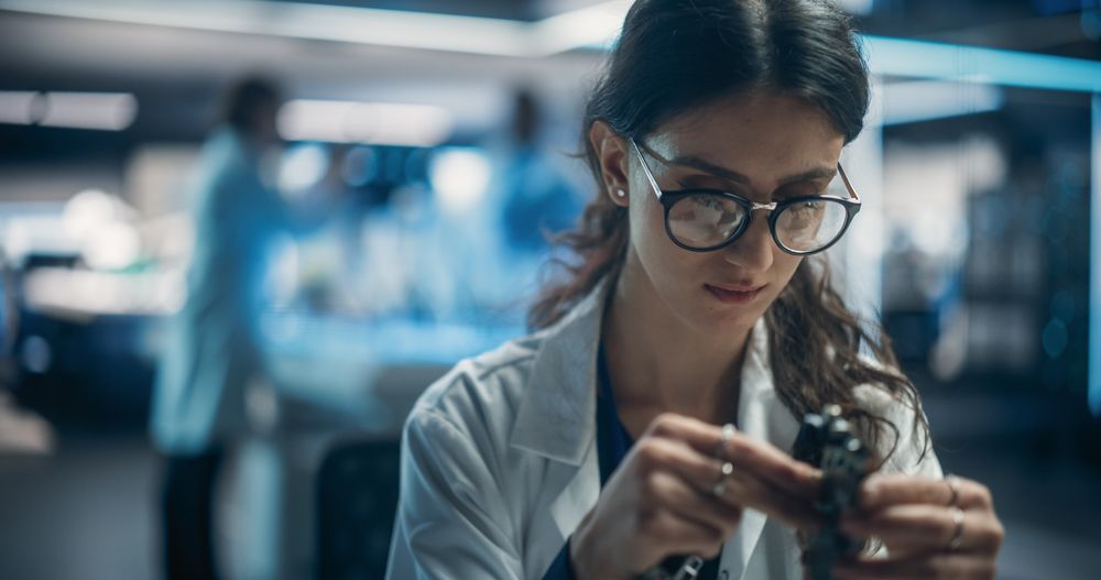 Focused Professional Female Engineer Working on Electronic Circuit Boards.