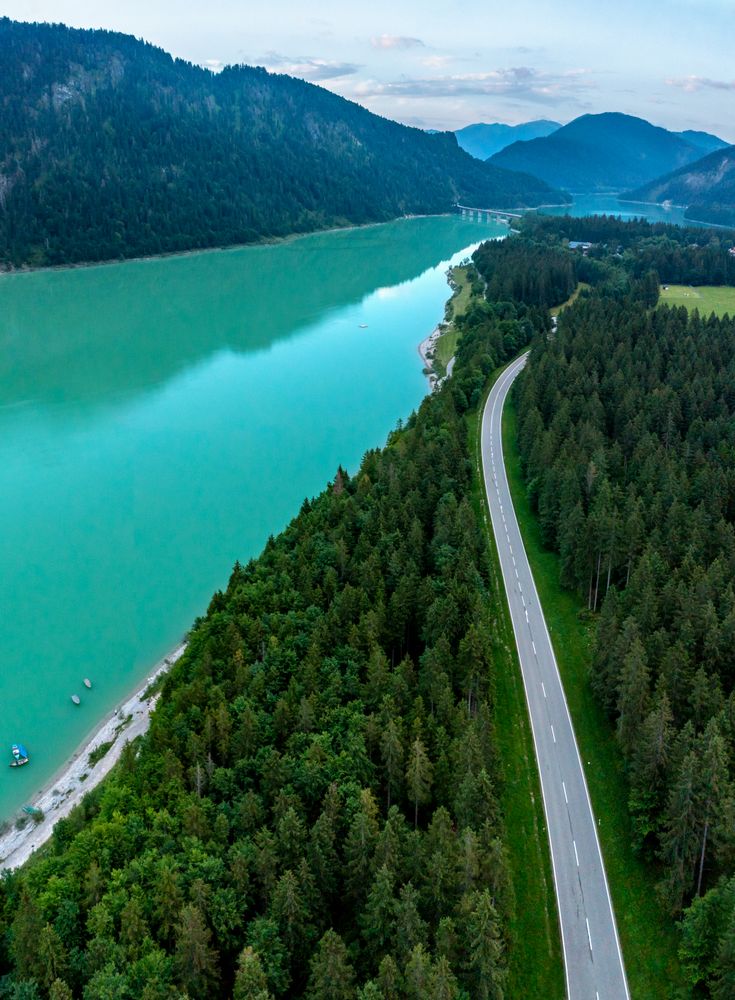 Drone shot in Bavarian Alps with Lake Sylventein and road through the forest