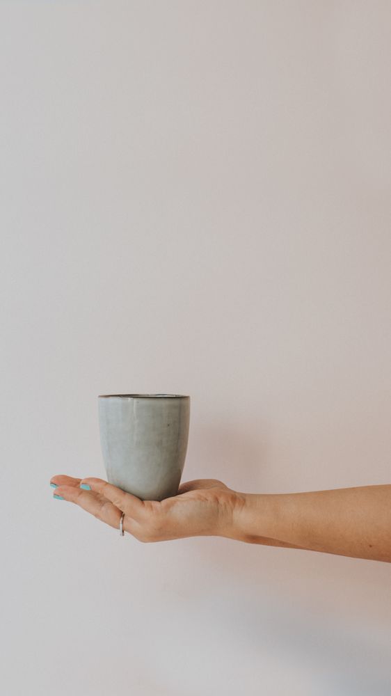 Big gray mug in outstretched hand