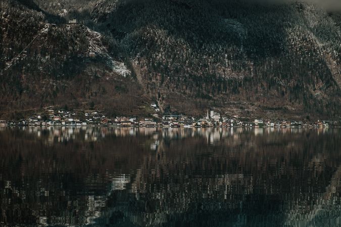 Crystal lake reflecting dark mountain and shore