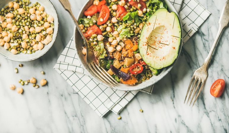 Healthy vegan lunch bowl with avocado, grains, vegetables, horizontal composition, with copy space