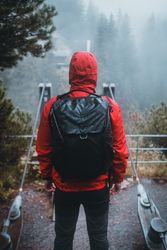 Man in red jacket and backpack standing outdoor