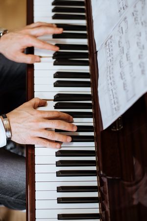 Crop male hands playing piano