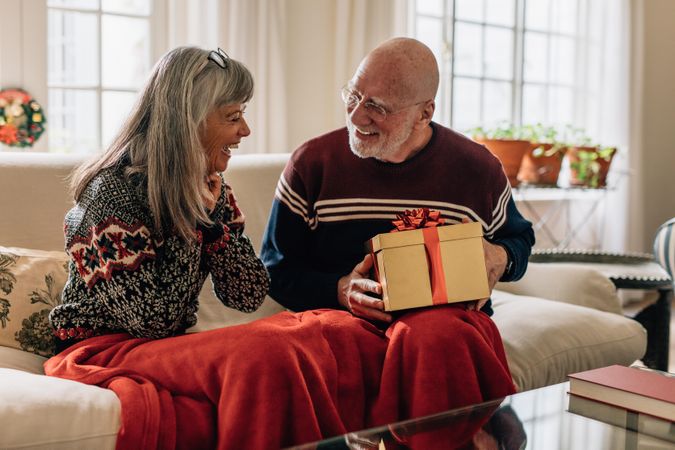Older man giving a Christmas gift to his wife
