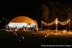 Exterior view of people celebrating wedding in tent 56zdP5