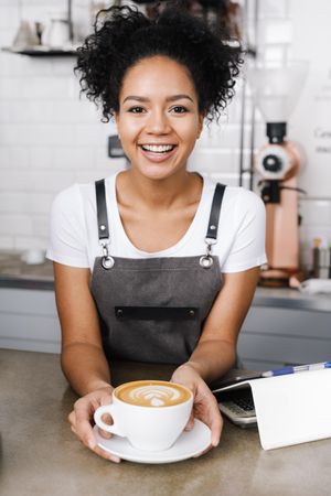 Smiling barista with cappuccino