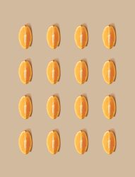 Pattern of orange fruit slices and pastel sand background