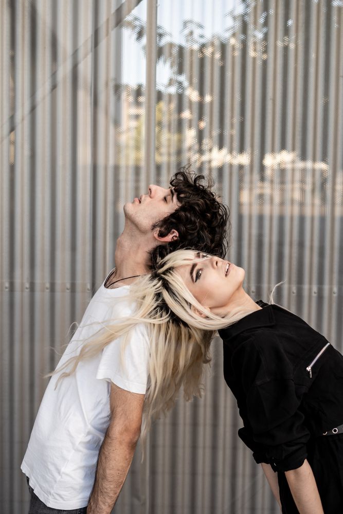Loving man and woman supporting each other while standing back to back