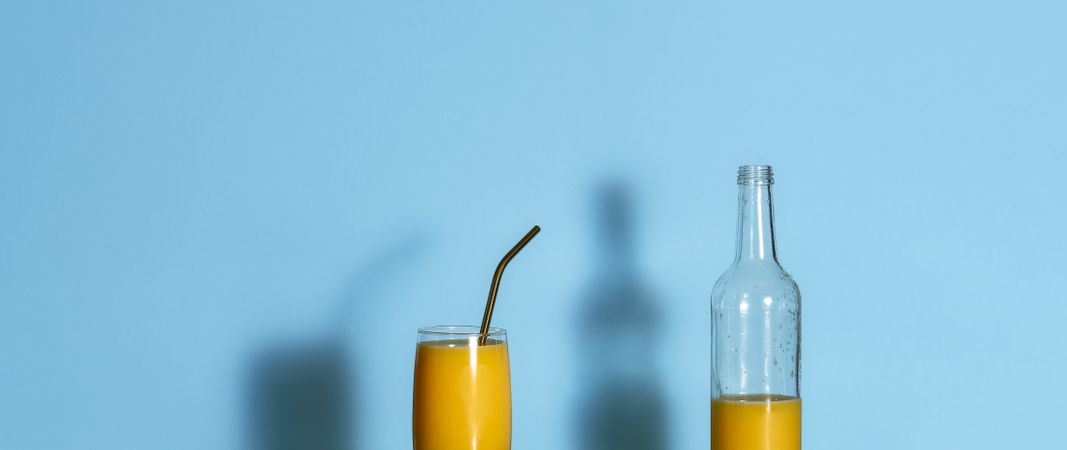 Orange juice in a glass bottle and cup