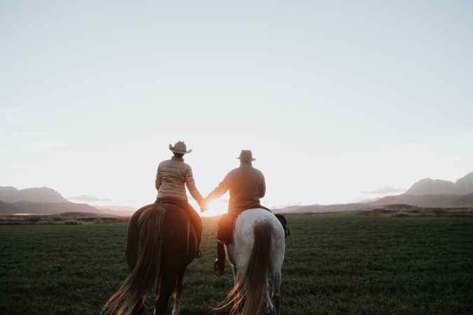 People on horses holding hands