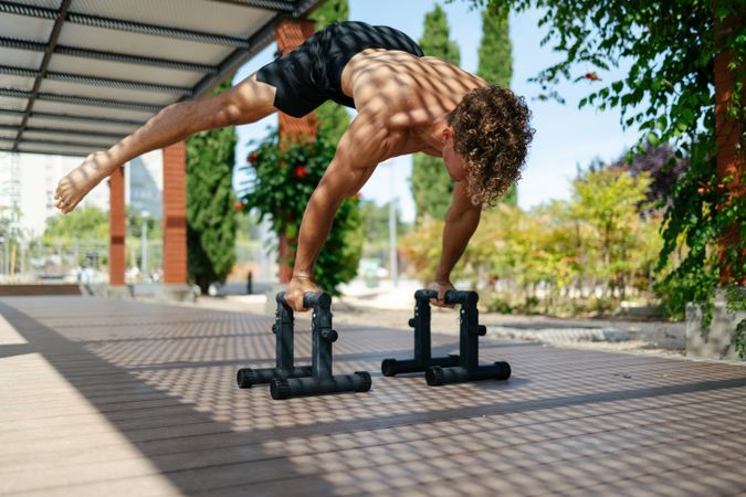 Strong young sportsman doing calisthenics