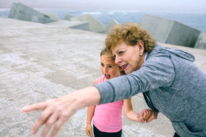 Mature sportswoman pointing with little girl