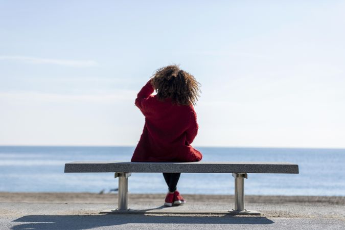 Back of woman enjoying view on seat overlooking the ocean