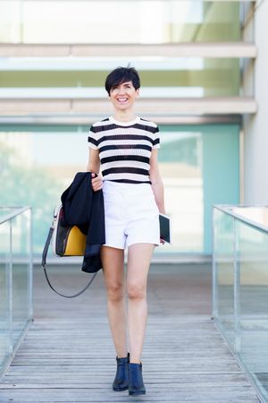 Woman walking down path outside of building smiling