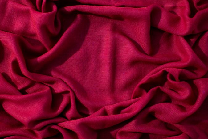Red fabric wavy crumpled background texture with copy space.