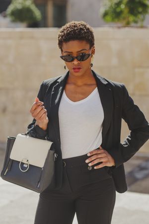 Stylish Black woman with handbag and sunglasses on street