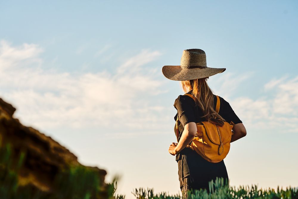Woman traveler in straw hat walking