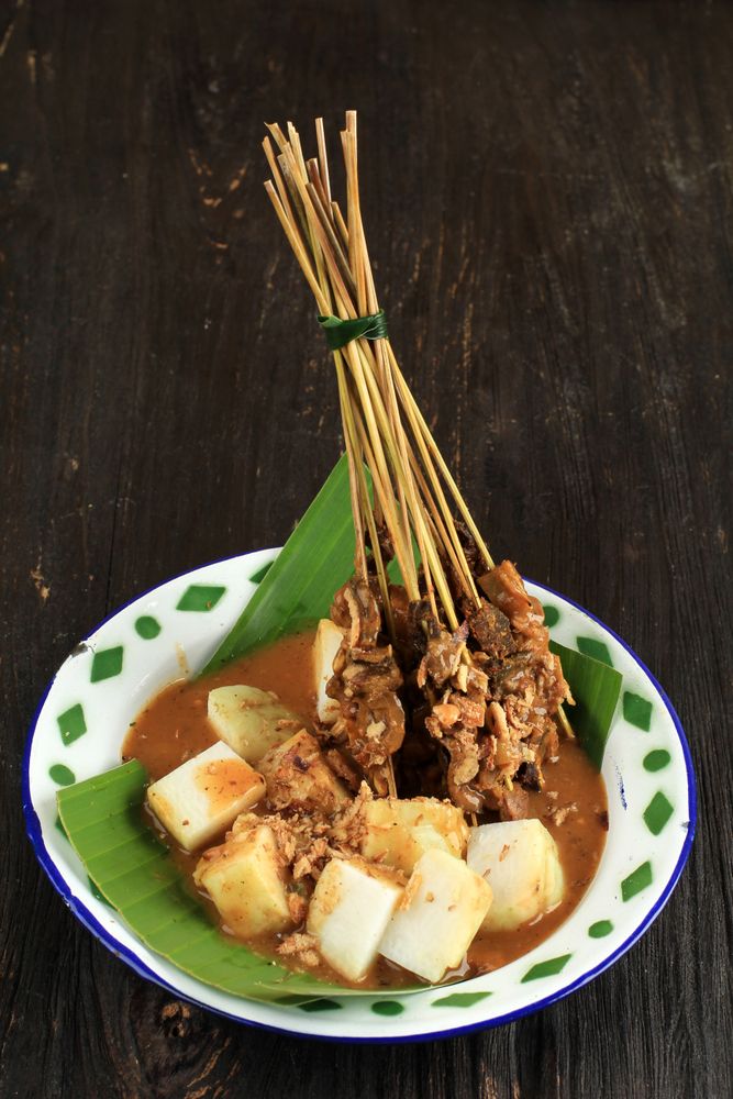 Bowl of beef sate skewers in spicy peanut sauce