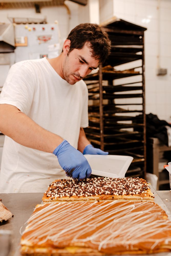 Anonymous baker spreading sprinkles on pastry