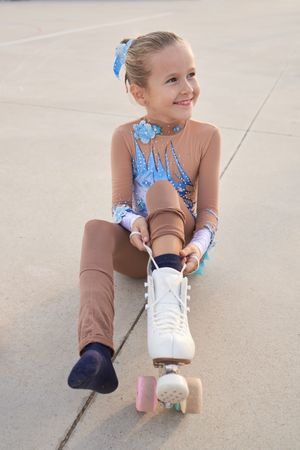 Cute girl tying shoelaces on roller skate
