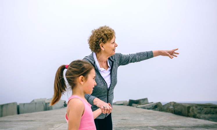Older sportswoman pointing with little girl