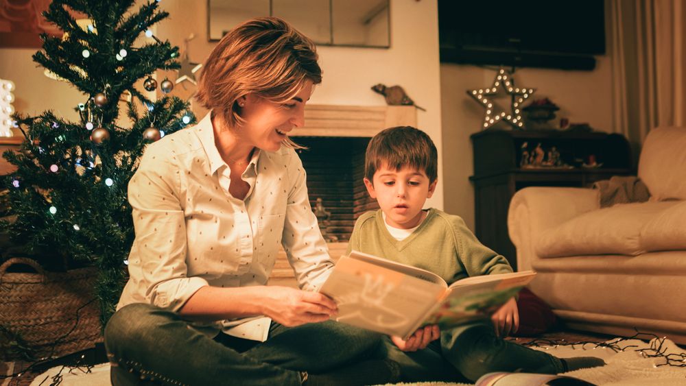 Mother reading book with son on Christmas eve