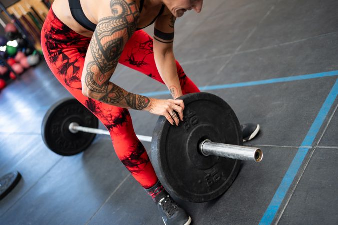 Woman adding weight to a bar for weightlifting
