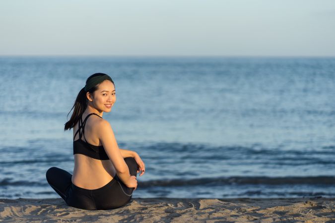 Sportive woman sitting in the on beach