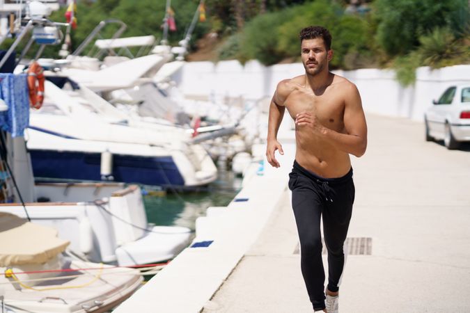 Shirtless male exercising on waterfront