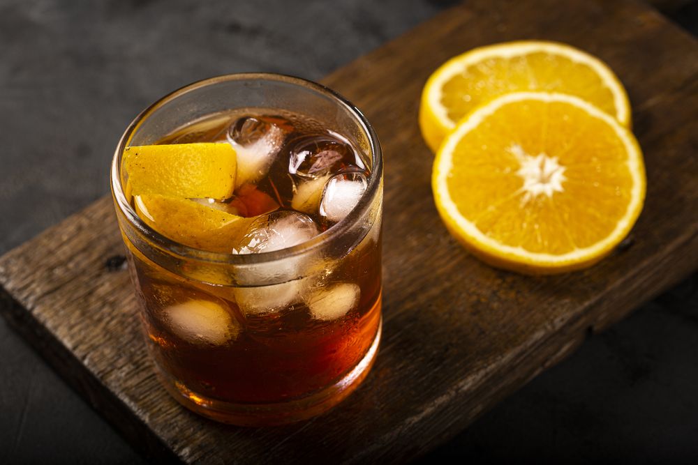 Negroni cocktail with orange, on dark background.