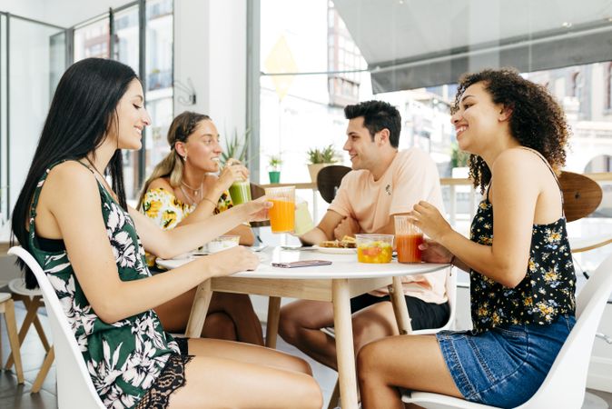 Diverse friends clinking glasses with smoothies