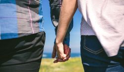 Unrecognizable couple holding hands