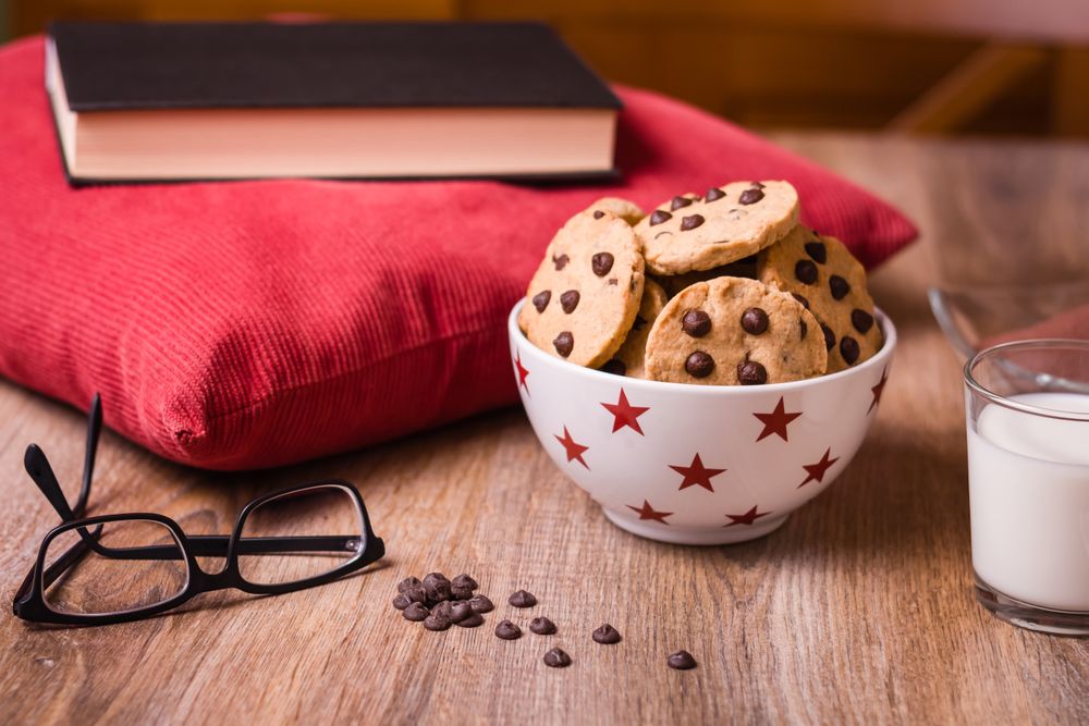 Chocolate chip cookies and milk on wood background