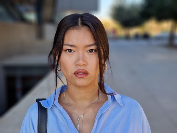 Chinese woman looking at camera with a serious expression in a city