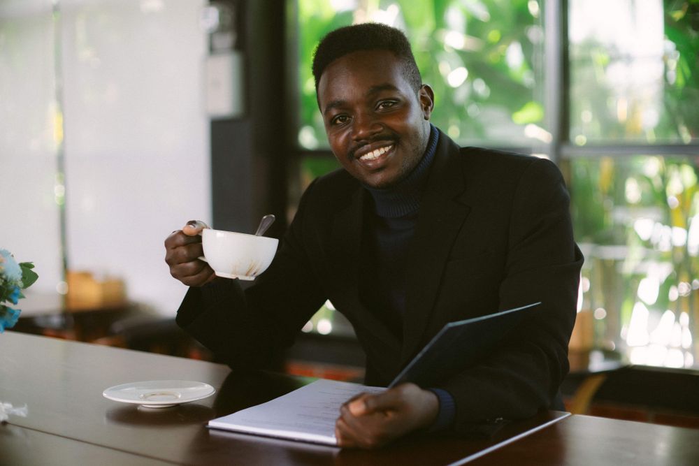 Man in blazer drinking coffee at a coffee shop