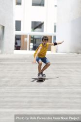 Excited teenage skateboarder riding on the city in a sunny day 5XrYWK