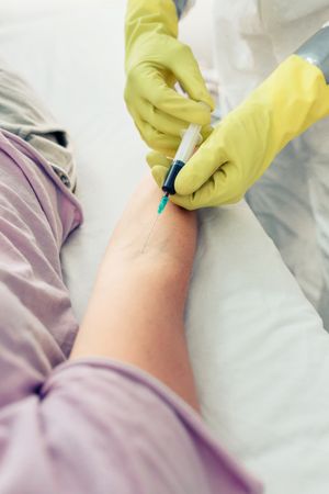 Doctor doing blood test to patient lying on the gurney