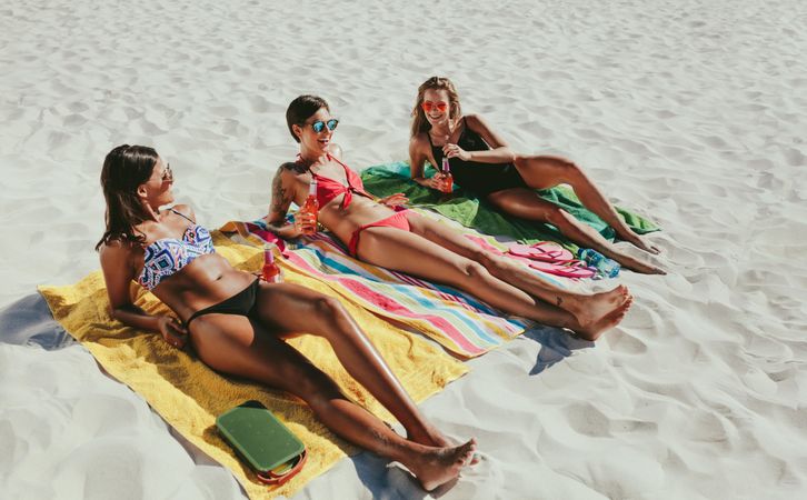 Slender females enjoying sunbathing on beach vacation