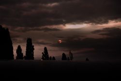Red moon over atmospheric cloudy nightsky