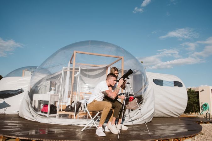 Young couple using astronomical telescope