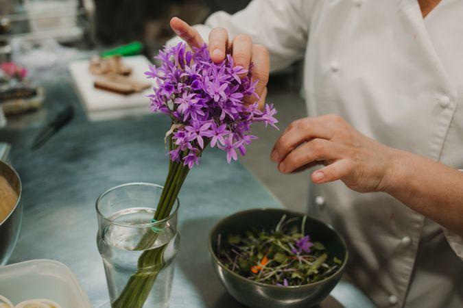 Woman preparing salad by hands at decorated table