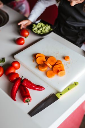 Anonymous kids preparing vegetables for salad