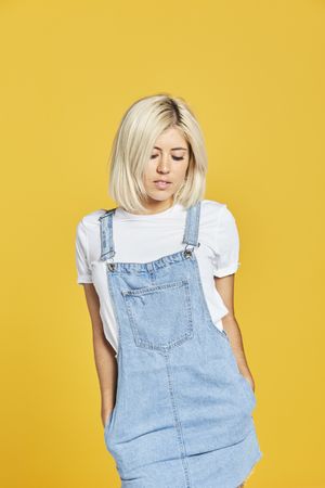 Trendy blonde female in denim sundress