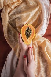 Papaya half held in woman’s hand