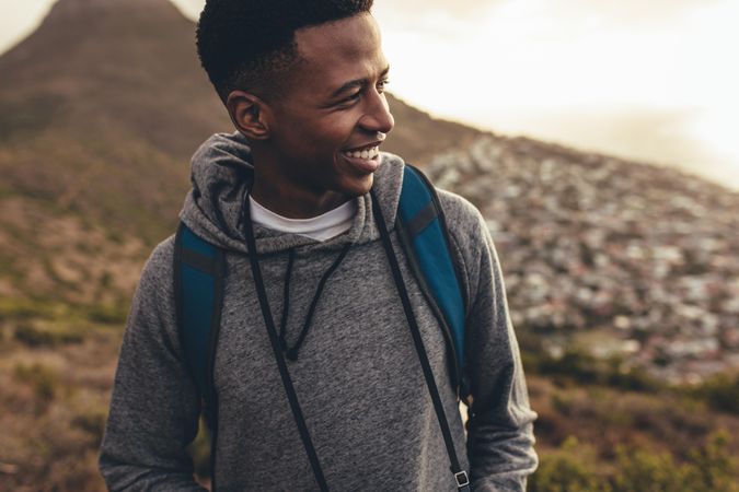 Young man smiling on hiking trip looking away