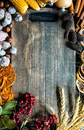 Top view of wooden board with seasonal nuts, berries, vegetable and fruits for fall season