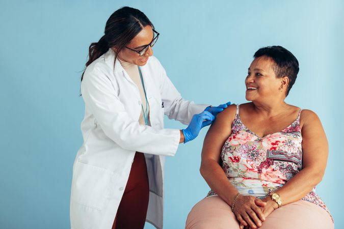 Healthcare professional giving flu shot to mature woman