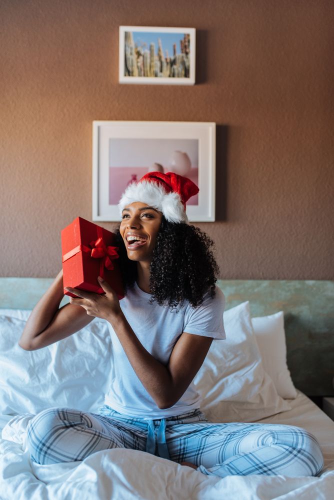 Woman with santa claus hat with a present