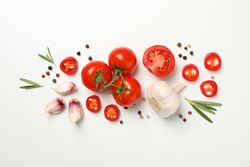 Tomatoes and ingredients on light background, top view
