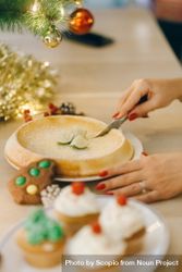 Person slicing pie on table with Christmas decoration 5XA1r4